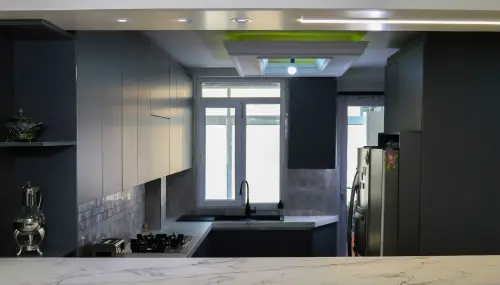 کابینت هایگلاس طوسی مدرن با دستگیره مخفی در آشپزخانه پنجره دار