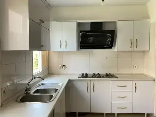 کابینت آشپزخانه ام دی اف سفید براق سبک مدرن با دستگیره فلزی طلایی